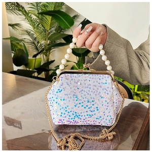 Detail of sequin evening bag featuring iridescent finish and white pearl handle strap