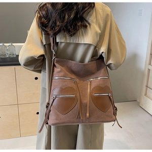 Detail of vintage brown corduroy hobo bag with two heart-shaped zipper pockets on the back