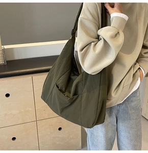 Detailed texture of olive green waterproof nylon tote bag with adjustable shoulder strap