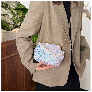 Detail of sequins on shell evening bag with pearl handle and golden chain strap