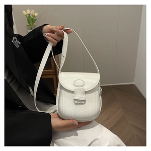 Close-up of white crossbody mini bag with vertical striped texture and saddle flap