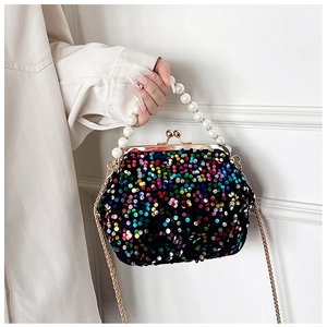 Detail of evening clutch bag with sequins, pearl handle, and golden metal chain strap
