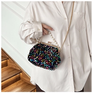 Detail of colorful sequined shell evening bag with pearl handle and metal chain
