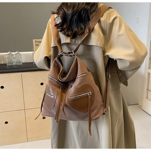 Detail of coffee corduroy backpack showing brown heart-shaped zipper pockets and adjustable straps