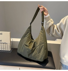 Detail of olive green nylon tote bag showing adjustable strap and soft wrinkled texture