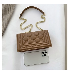 Detail of dark brown quilted crossbody bag with golden chain and phone for size reference