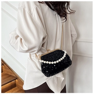 Detailed shot of black sequin clutch bag with pearl handle and gold chain strap