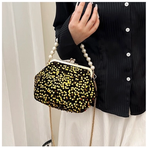 Detail of sequin evening bag featuring a white pearl handle and gold chain strap