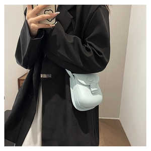 Detail of mint green mini crossbody bag with vertical ribbed texture and flap closure