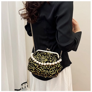 Detail of evening bag showing gold sequins, pearl handle and metal clasp closure
