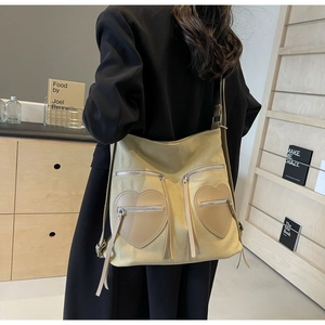 Rear view showing the large khaki corduroy backpack with double heart pockets and long tassels