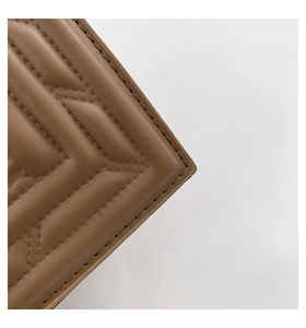 Detail of brown leather handbag featuring precise V-shaped quilting and fine stitching