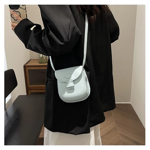 Crossbody view of light blue small square bag with vertical stripe texture