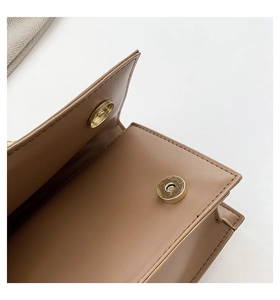 Detail of magnetic metal clasp closure on high-quality brown leather handbag