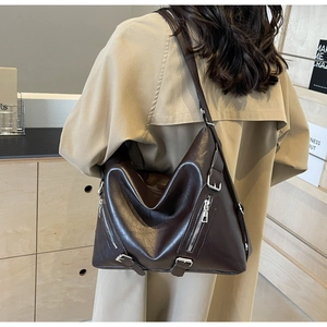 Detail view of large dark brown leather hobo bag with silver zipper and buckle details