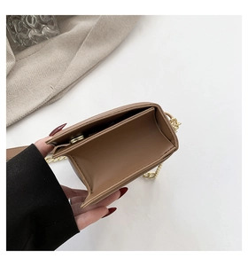 Detailed interior view of brown leather crossbody bag with chain strap and magnetic snap