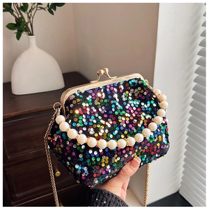 Close-up of sparkling colorful sequin evening bag with pearl handle and metal chain