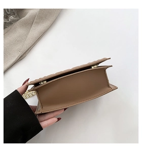 Detail view showing wide flat bottom and neat stitching of the brown leather handbag