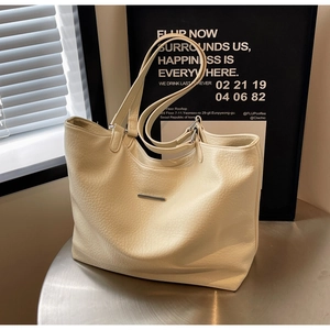Detailed close-up of cream white tote bag with lychee grain texture and silver hardware