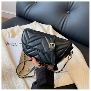 Detailed view of black V-quilted faux leather bag with elegant gold chain strap
