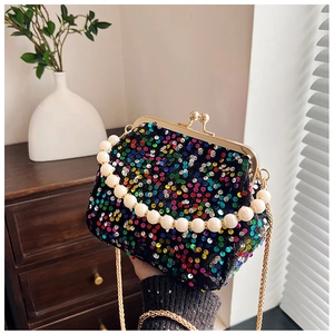 Detailed shot of sequin evening clutch with pearl handle and golden chain strap