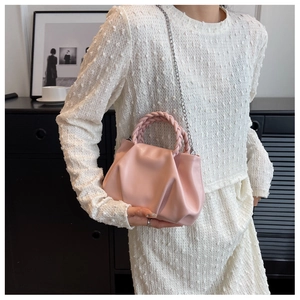 Detailed close-up of a pink pleated cloud bag with a braided handle and metal chain strap