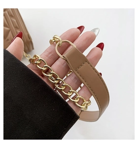 Detailed close-up of brown leather shoulder strap with elegant gold metal chain links