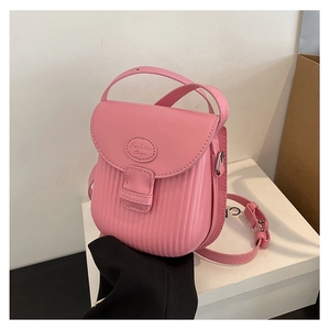 Detail of pink small crossbody bag featuring vertical striped texture and silver buckles