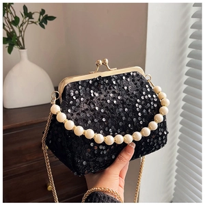 Detail of elegant black sequin evening bag with pearl handle and golden chain strap
