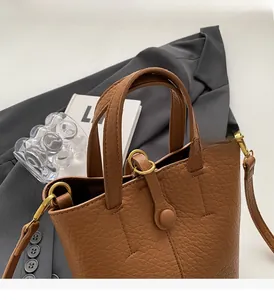 Detailed macro view of the brown lychee grain leather texture and gold metal hardware