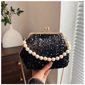 Close-up of black sequin evening bag with elegant pearl handle and vintage metal clasp