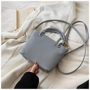 Close-up of pleated vertical stripes and golden hardware on the grey bucket bag