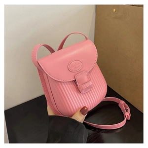 Detail of pink mini crossbody bag featuring vertical embossed texture and fashion logo