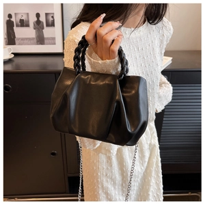 Detail of black pleated cloud bag with braided handle and silver metal chain strap