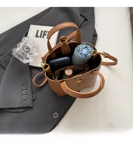 Top view of brown lychee grain leather bucket bag showing spacious interior and inner zipper pocket