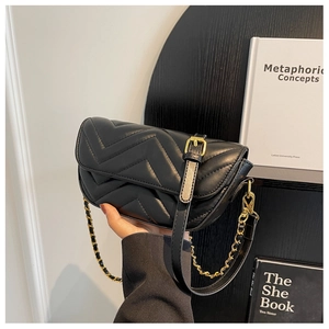 Close-up of black V-quilted leather handbag with elegant gold chain and leather shoulder strap