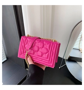 Detail of rose red rectangular chain bag with classic quilted leather and gold hardware