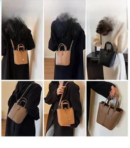 Detail shot of mini bucket bags in brown and black litchi leather with adjustable straps