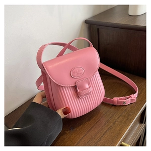 Detailed shot of pink crossbody bag featuring vertical striped texture and circular logo