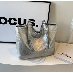 Close-up of silver tote bag showing crinkled leather texture and metallic finish
