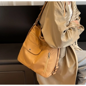 Detail view of the large mustard yellow tote bag with multiple pockets and silver hardware