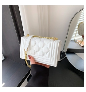 Detail of white quilted crossbody bag featuring elegant gold chain and PU leather finish