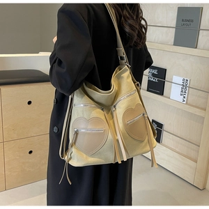 Detail of vintage beige corduroy backpack featuring heart pockets and stylish tassels