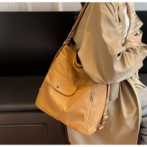 Detail of yellow multi-pocket tote bag showing front flap snap and durable nylon texture