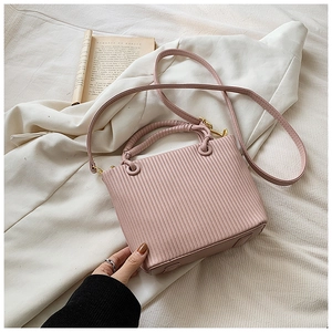 Detailed close-up of pink pleated bucket bag with gold hardware and stylish top handles