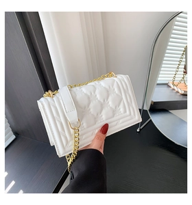 Detail of white quilted handbag with gold chain strap and elegant rhombus pattern