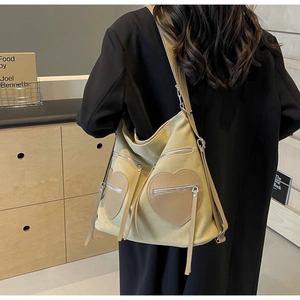 Detailed view of cream corduroy backpack featuring heart-shaped pockets on black wool coat
