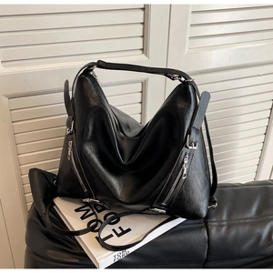 Detail shot of the large black leather hobo bag with silver zipper accents and lychee texture