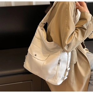 Detailed view of white large tote bag with multi-pocket design and silver metal hardware