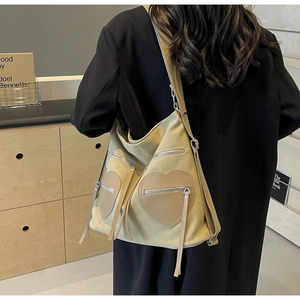 Detailed back view of khaki canvas shoulder bag with heart-shaped pockets and leather trim